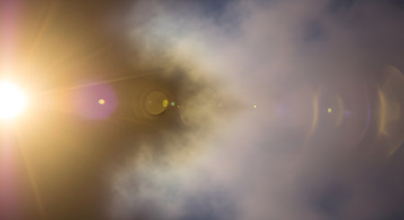 A vibrant lens flare dominates the left side, casting a warm glow across a hazy, textured background with muted, ethereal colors.の素材