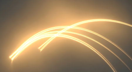 Golden light streaks curve and flow across a blurred, neutral background, creating an abstract and ethereal effect.の素材
