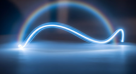 A vibrant blue light trail curves dynamically, creating an abstract arc over a smooth, reflective surface with a soft glow.の素材
