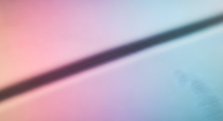 A gentle gradient transitions from pink to blue, bisected by a dark diagonal line with scattered, faint sparkles.の素材