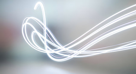Dynamic white light streaks create an abstract, flowing pattern against a blurred, neutral backdrop, suggesting motion and energy.の素材