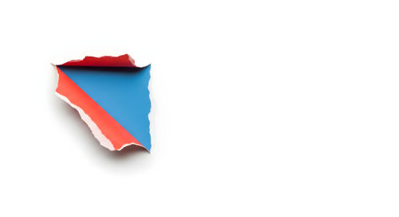 A small piece of torn paper reveals vibrant layers of red, blue, and white, creating a striking abstract composition against a white background.の素材