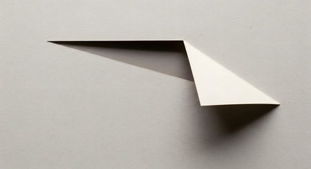 A minimalist composition featuring a folded paper element casting a sharp shadow, creating abstract geometric shapes and depth.の素材