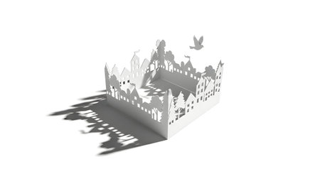 A delicate white paper cutout of a castle is illuminated, casting long, complex shadows across a stark white surface.の素材