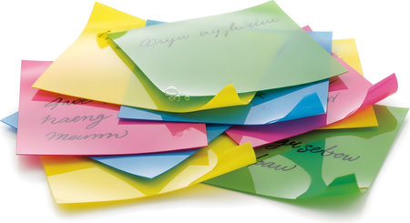 A vibrant, scattered pile of sticky notes in various bright colors, some with handwritten text visible, suggesting tasks or reminders.の素材