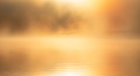 A soft, blurred background with warm golden hues, featuring bokeh effects and a gentle light glow.の素材