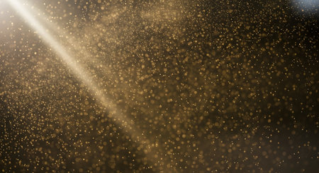 A bright sunbeam shines diagonally across a textured background filled with countless small, illuminated particles suspended in the air.の素材