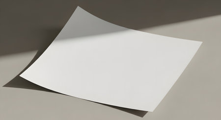 A single, blank white sheet of paper casts a sharp shadow on a neutral background, creating a minimalist and modern aesthetic.の素材