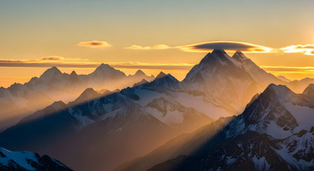 Majestic mountain range illuminated by a warm, golden sunset, casting long shadows and highlighting snow-capped peaks with a unique lenticular cloud.の素材