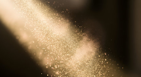 Tiny golden particles suspended in the air, catching the light from a diagonal beam, creating a magical, sparkling effect.の素材