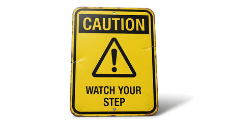 A weathered yellow caution sign with black lettering and an exclamation mark symbol, warning to watch your step.の素材
