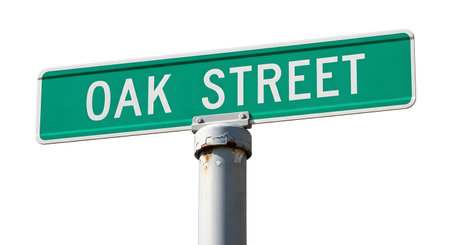 A close-up view of a green street sign displaying 'OAK STREET' in white lettering, attached to a silver pole against a white background.の素材