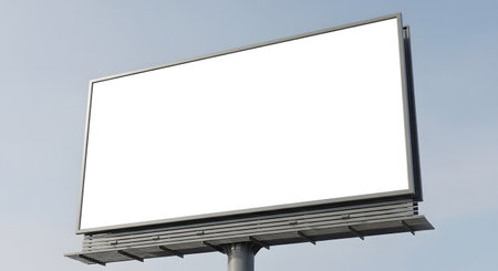 A large, empty billboard stands tall against a pale blue sky with subtle clouds, awaiting a new advertisement.の素材