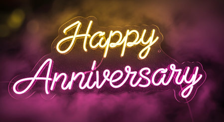A glowing neon sign displays 'Happy Anniversary' in elegant script font with warm yellow and vibrant pink lighting.の素材
