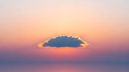 A serene image capturing a single cloud against a vibrant orange and purple sky during sunset. The cloud is backlit, creating a striking contrast with the colorful background.の素材