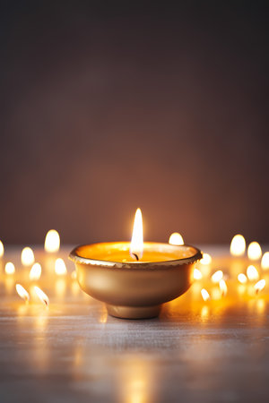 Beautiful diwali diya with burning candles on wooden tableの素材