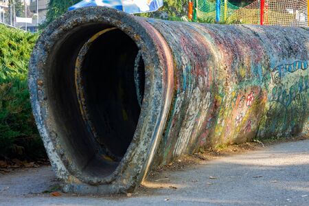 Very old tunnel for children's play, made of concrete elements, decorated with children's drawings....