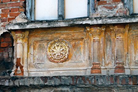 abandoned building, whose damaged facade still shows decorative elementsの写真素材