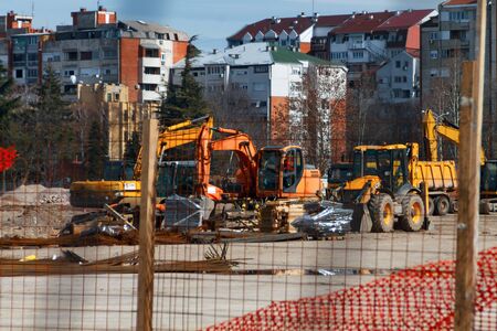construction site construction machinery, photographed through a protection netの写真素材