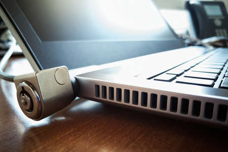 laptop on the desk secured with a 
padlock, sometimes called kensingtonの写真素材