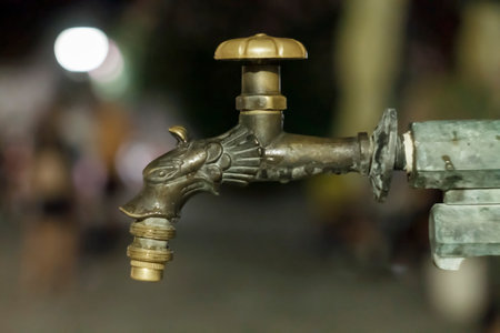 Old decorative faucet on the fountain at night. Adobe RGB color space.