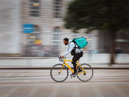 A man delivering fast food on his bike in Manchester City Centreのeditorial素材