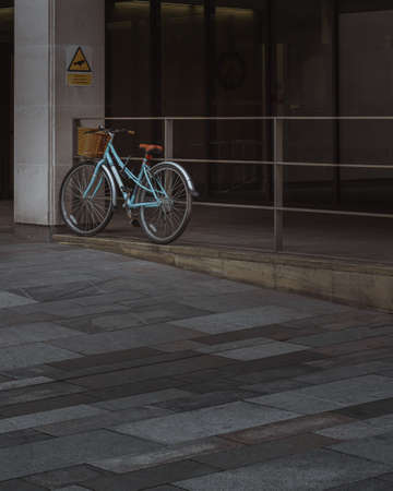 A lonely bike leaning against railing in Manchester city centre in the United Kingdomのeditorial素材