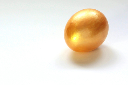 Big Golden chicken egg on white backgroundの写真素材