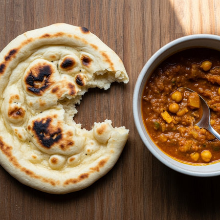 Savor the flavors of India with this mouth-watering chana masala served with a side of freshly baked naan bread on a rustic wooden tableの素材