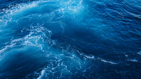 A captivating aerial view of turquoise ocean waves crashing against the deep blue sea showcasing the natural beauty of the oceans surface The image highlights the dynamic movement of the water as it flows and creates white foam patternsの素材