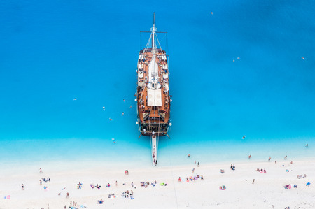 large sail cruise ship anchored at white sand beach, seen from aboveの写真素材