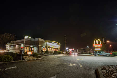 January 21, 2019: McDonald's Restaurant in Coos Bay, Oregon at night, with cars in parking lot.のeditorial素材