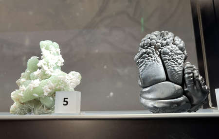 Gems, minerals and previous stones on display in a glass case at museum.