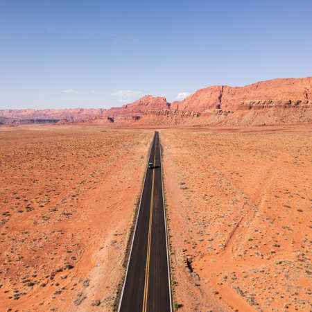 Car travels on highway in Northern Arizona through scenic landscapeの写真素材