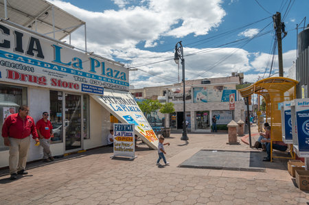 Employees wait outside a pharmacy in Nogales Mexico to attract customers.のeditorial素材
