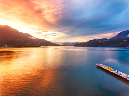 Lake Caldonazzo in Trentino during a spectacular sunset. Orange and blue colored sky in the evening.の写真素材