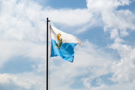 National flag of San Marino in front of blue cloudy skyの写真素材