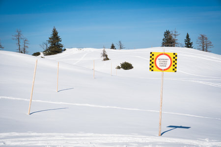 Sign warning in multiple languages of closed skiing area due to avalanche or other danger. Caution and risk for hiking and skiing activity.の写真素材