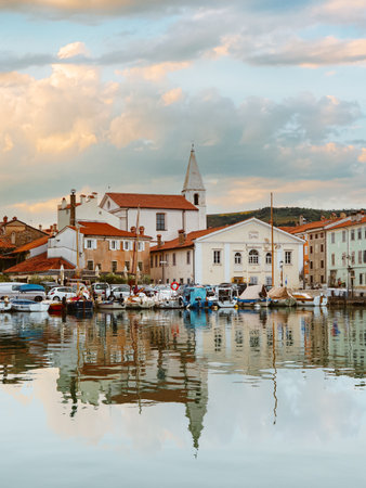 Harborfront Panorama of Izola with Reflections of Boats and Historic Architectureの写真素材