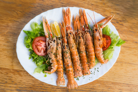 Grilled Scampi Seafood Plate with Fresh Salad on Wooden Tableの写真素材