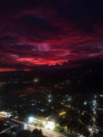 Red sky in sunset time with cloudy weather above indonesian village
