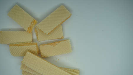 Tasty wafer sticks on white background, flat lay. Sweet food