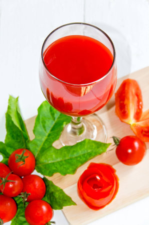 Glass of fresh tomato juice on white wooden table, closeup.の写真素材