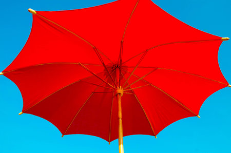 red beach umbrella with blue skyの写真素材