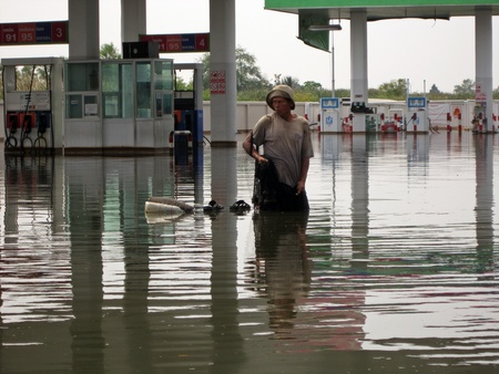 LAMLUKKA (PATHUMTHANI), THAILAND  CIRCA NOVEMBER 2011 - An unidentified man fishes with a net in the floodwater circa November 2011 in Lamlukka. The entire province has been flooded as a result of an exceptional and unprecedented rainy season.のeditorial素材