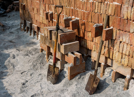 Two shovels against bricks wall, bricklayerの写真素材