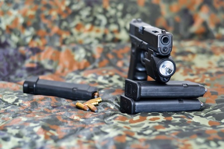 9mm military sidearm with a tactical laser/light-module on camouflageの写真素材