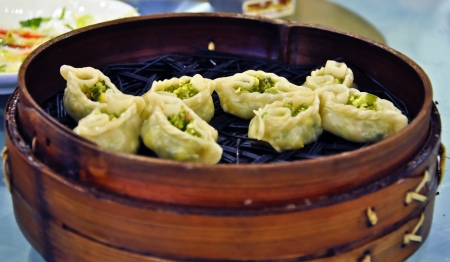 delicious steamed chinese dim sum being served in a bamboo basketの写真素材