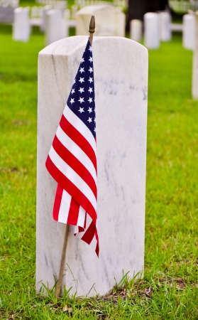 tombstones on a national cemetery with the american flagの写真素材