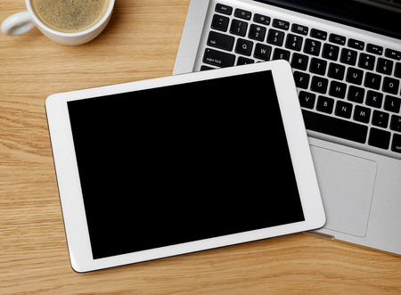 Directly above view of working table with digital tablet, laptop and coffeeの写真素材